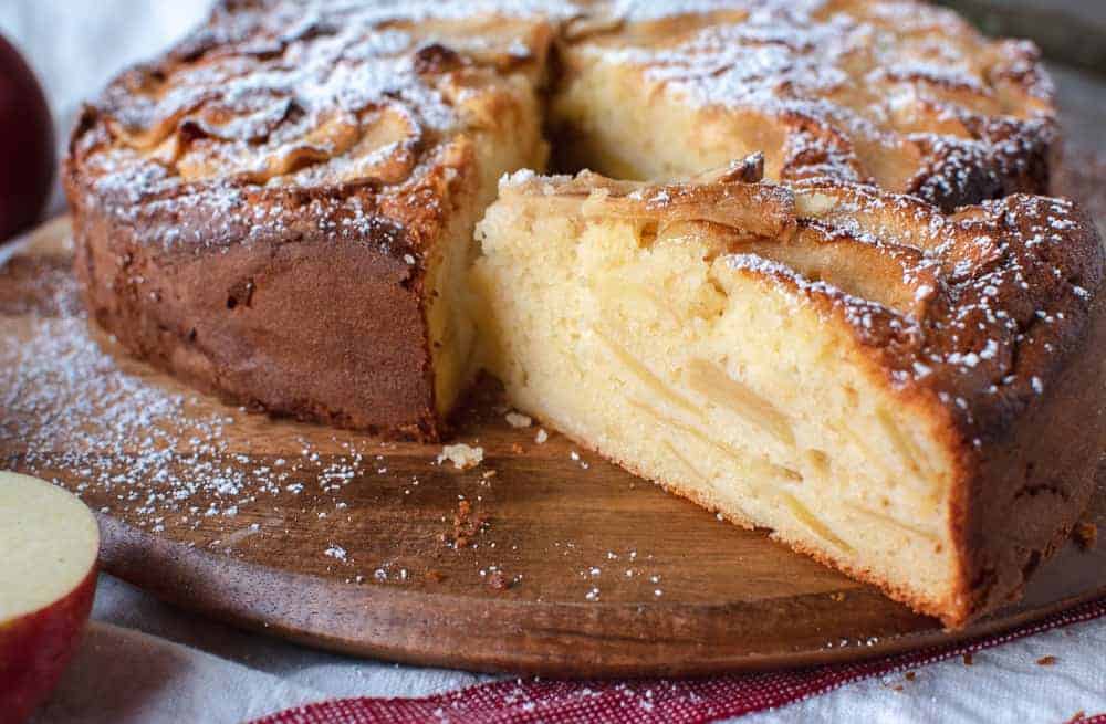 Italian apple cake with a wedge cut and showing the inside.