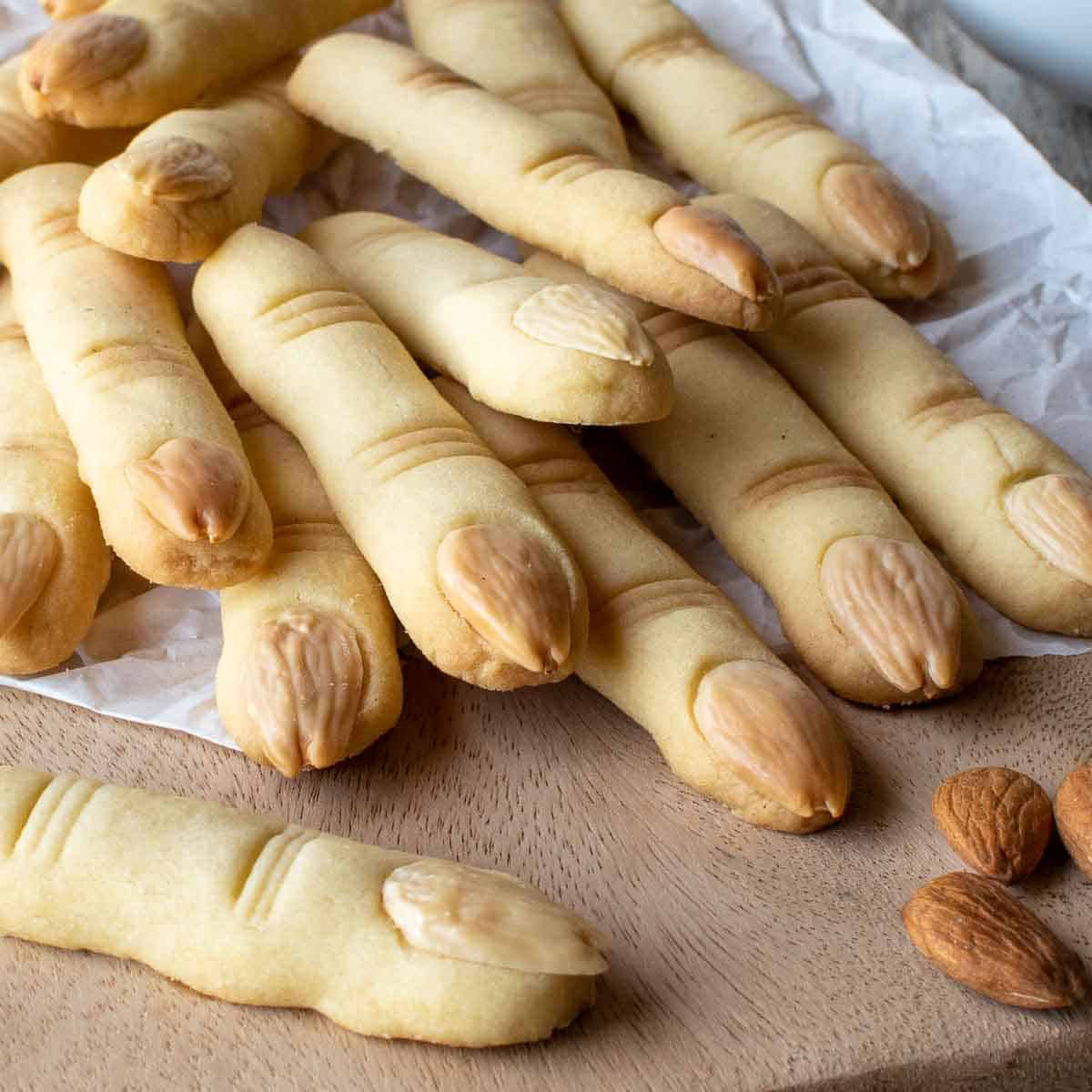Witches Fingers cookies piled onto a wooden board.