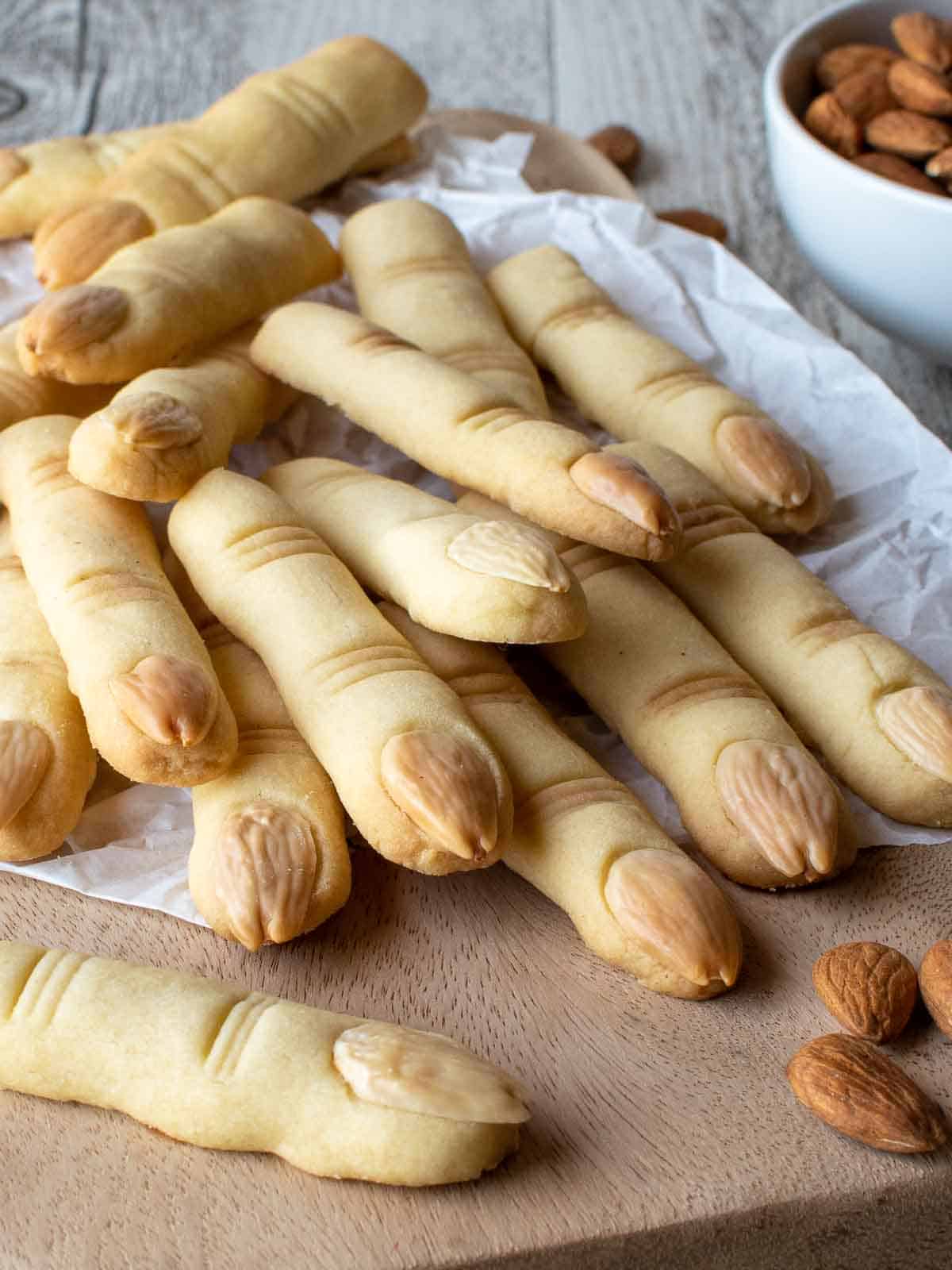 Witches Fingers cookies piled onto a wooden board.