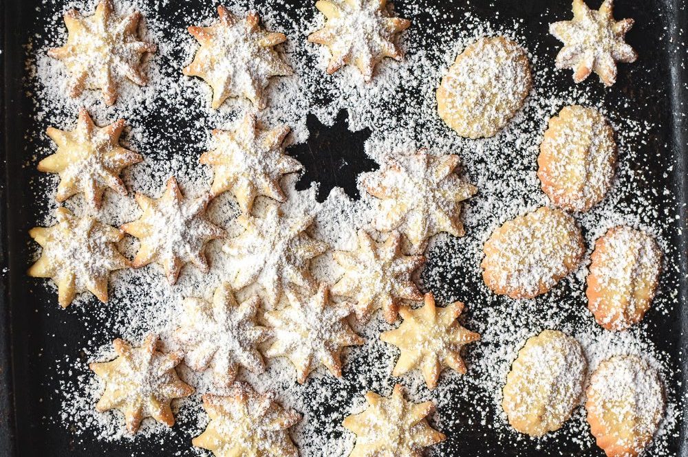 These buttery Spritz Cookies are delicious and not too sweet. The best thing about Spritz cookies is that they are easy and quick to make. #spritzcookies #cookies #butterycookies #christmascookies spritz cookies dusted with powdered sugar
