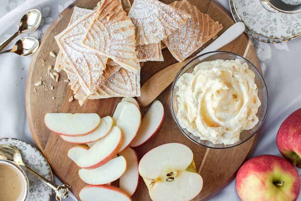 sweet ricotta on a board with apple slices and pizzelle.