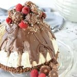 christmas ice cream pudding with chocolate drip decorated with chocolates and raspberries