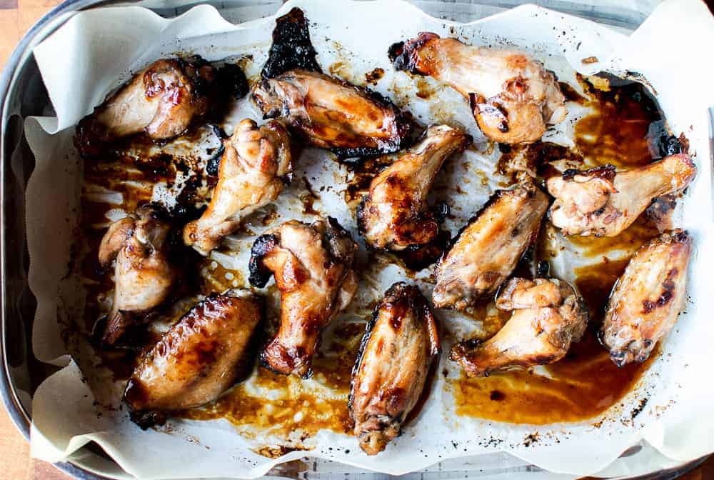 Honey baked chicken wings in baking pan lined with paper