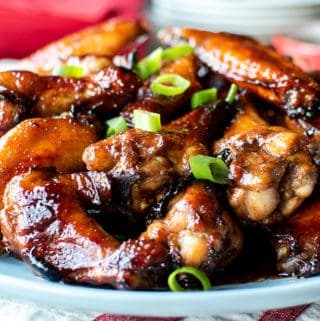 Pile of honey baked chicken wings on blue plate