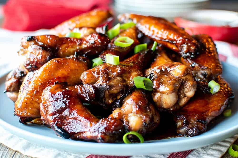 Pile of honey baked chicken wings on blue plate