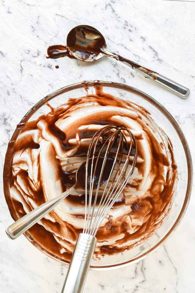 Scraped bowl, whisk and spoons after preparing chocolate pudding recipe viewed from above