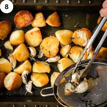 Roasted potatoes with garlic and rosemary being added.