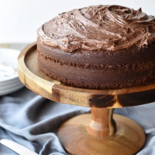 Frosted Chocolate cake on wooden cake stand