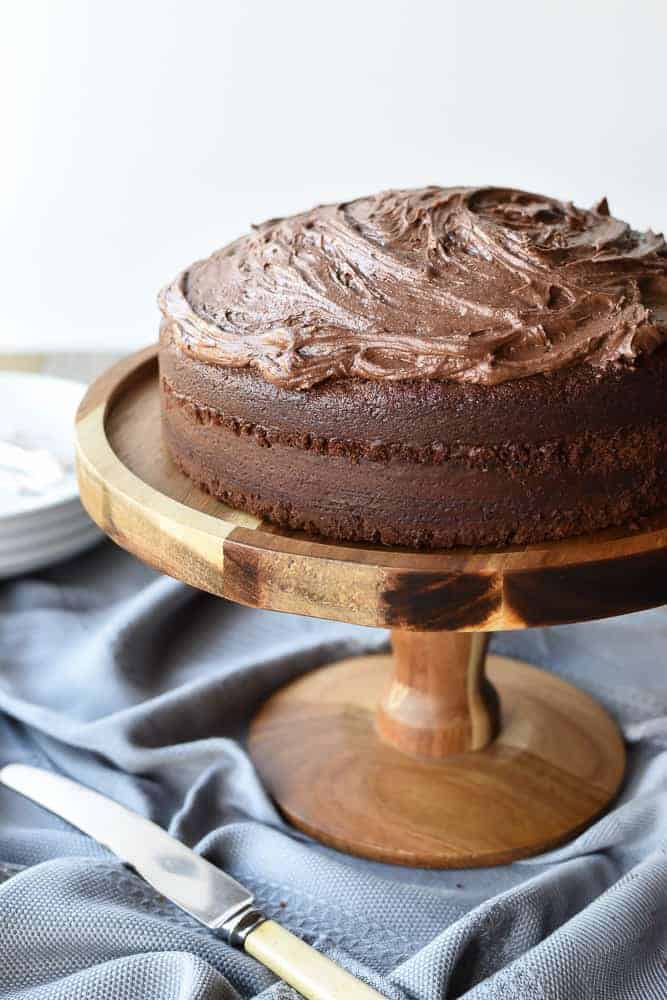 Frosted Chocolate cake on wooden cake stand