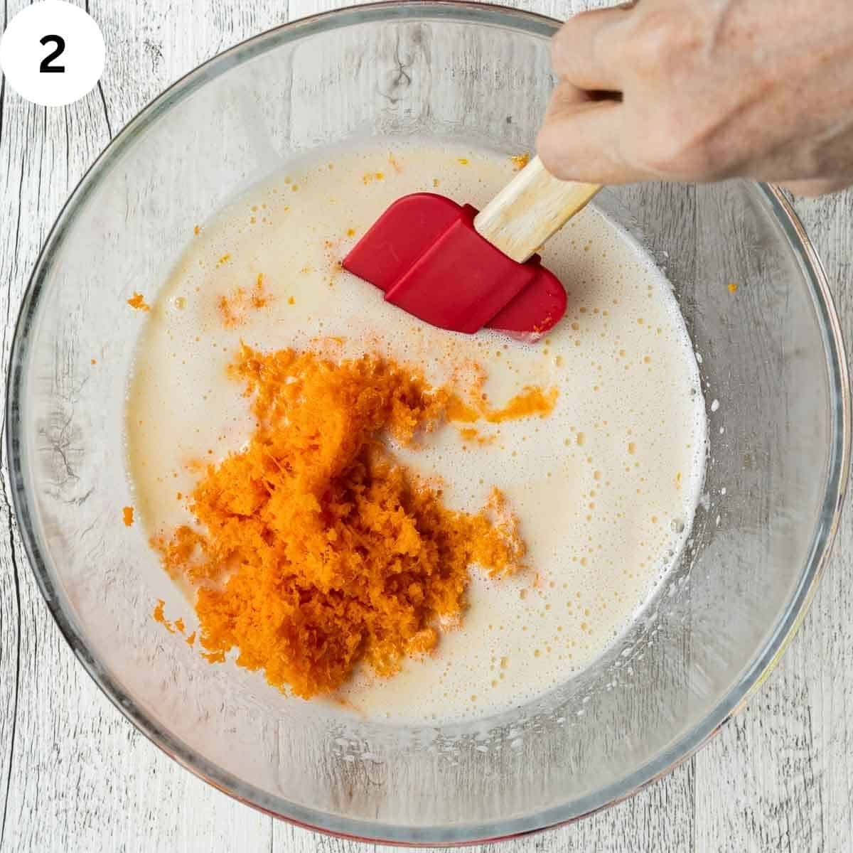 Stirring grated carrots into frothy, creamy mixture.