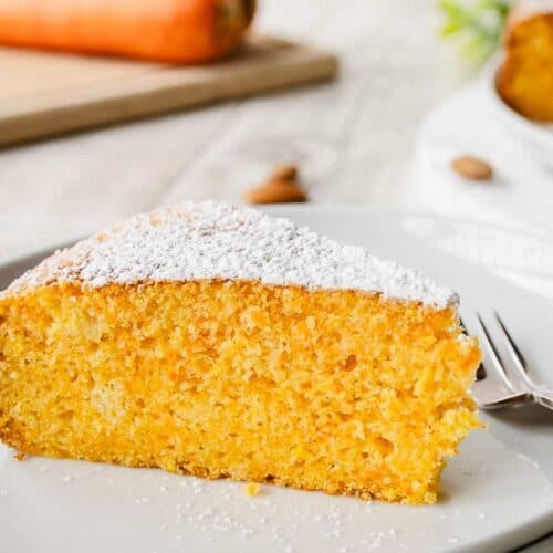 Close up of a wedge of orange colored cake.