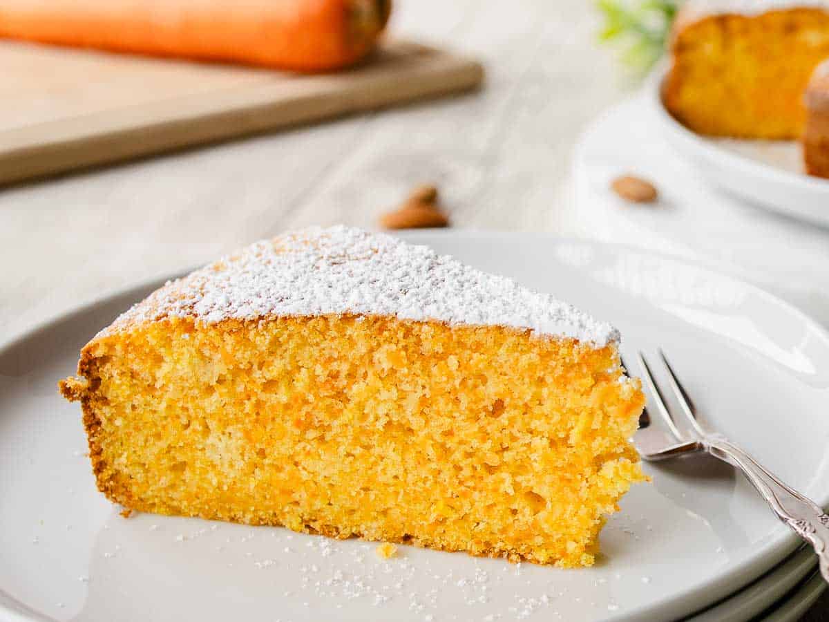 Close up of a wedge of orange colored cake.