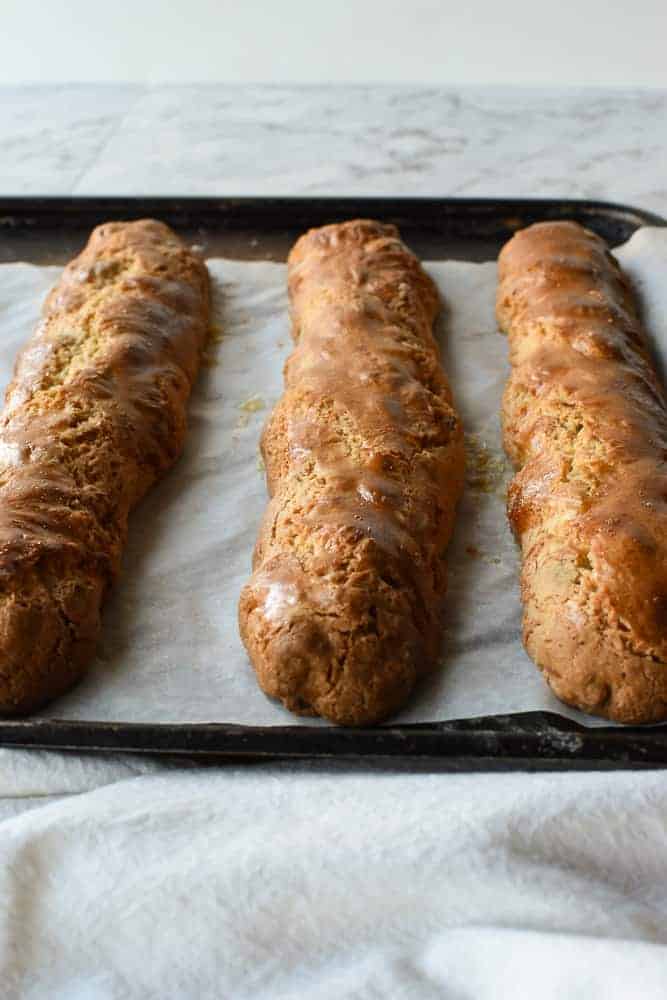 Three baked, oblong shaped cakes on baking tray.