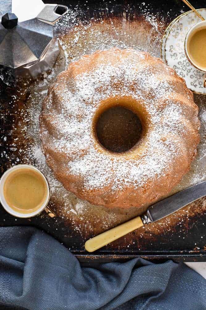 this cake with knife, two espresso cups of coffee and coffee moka pot viewed from above.