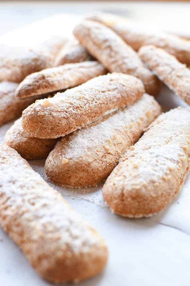 pile of savoiardi dusted with powdered viewed from an angle.