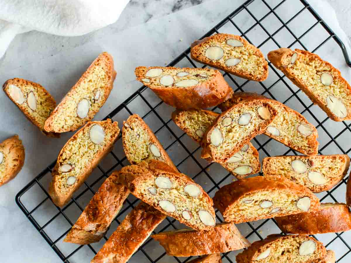 Almond biscotti on a black wire cooling rack viewed from above.