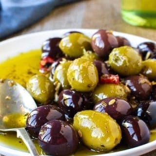 white plate of assorted olives viewed from the front