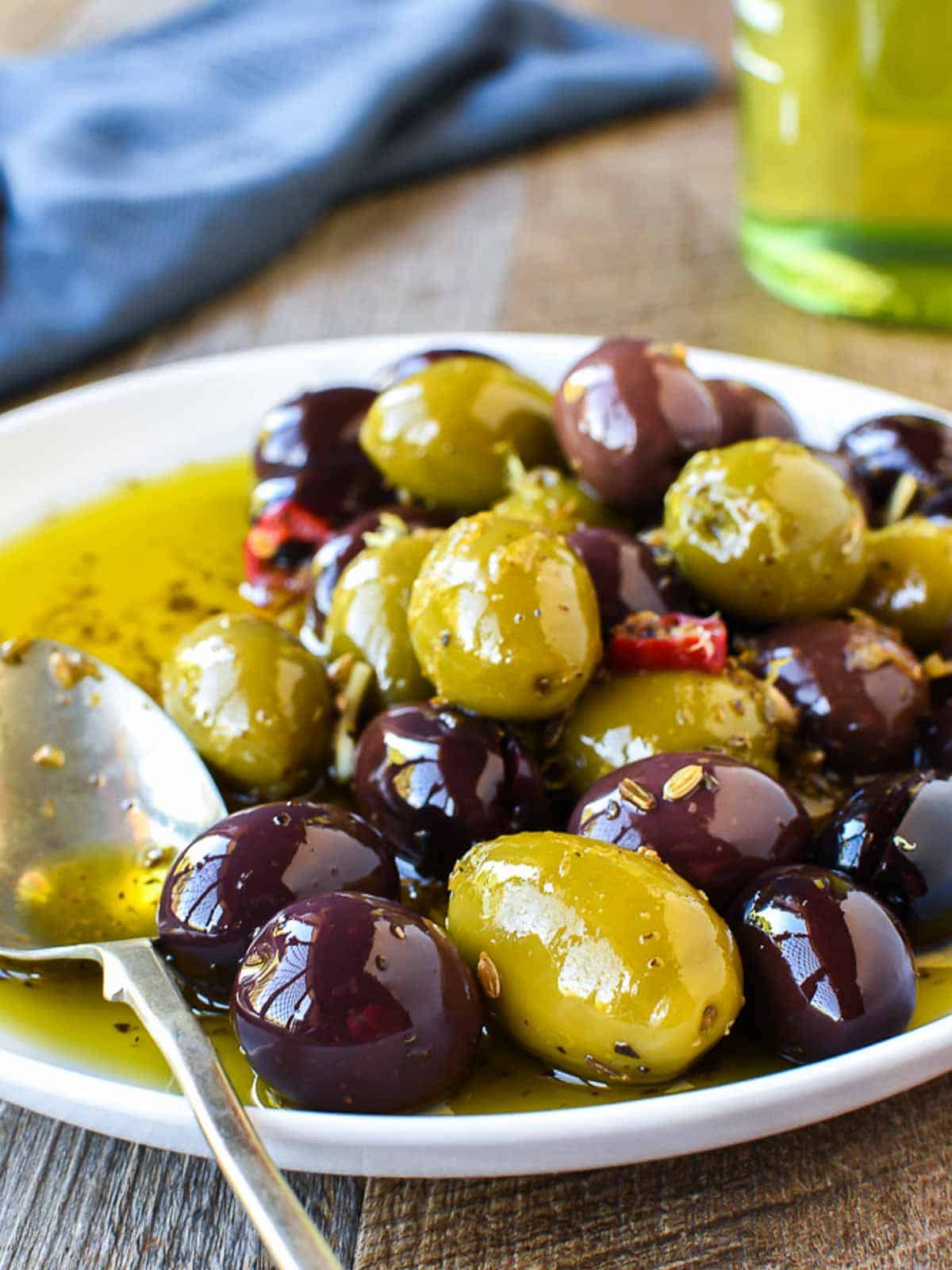 white plate of assorted olives viewed from the front.