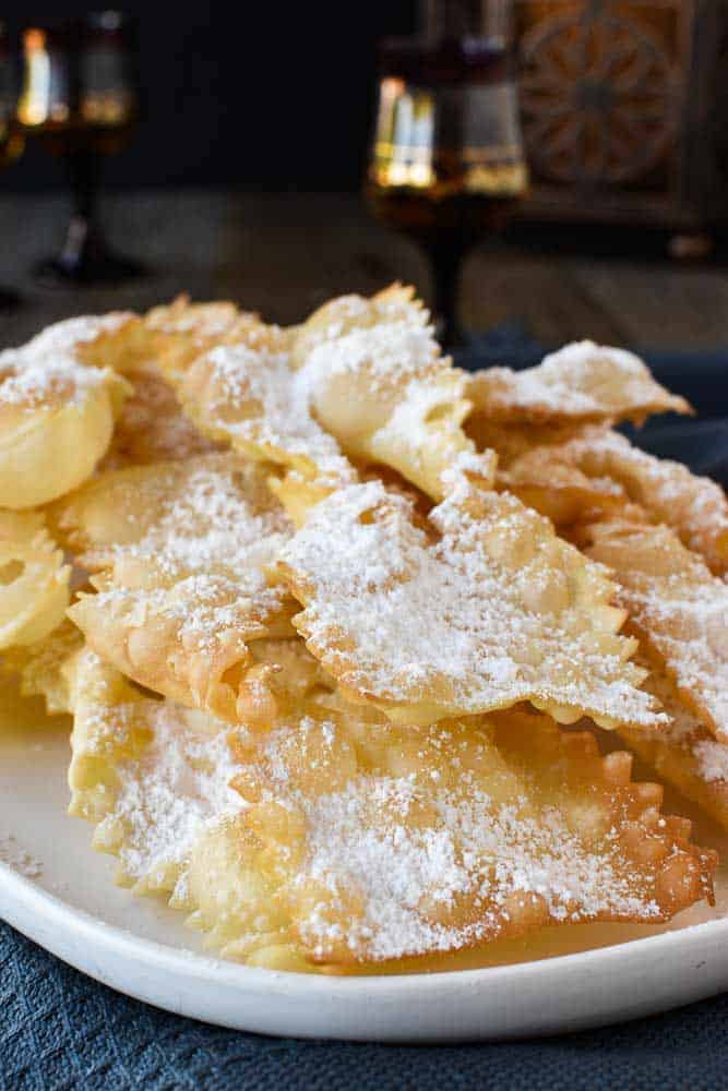 Fried Italian pastries - crostoli dusted with powdered sugar viewed from the front