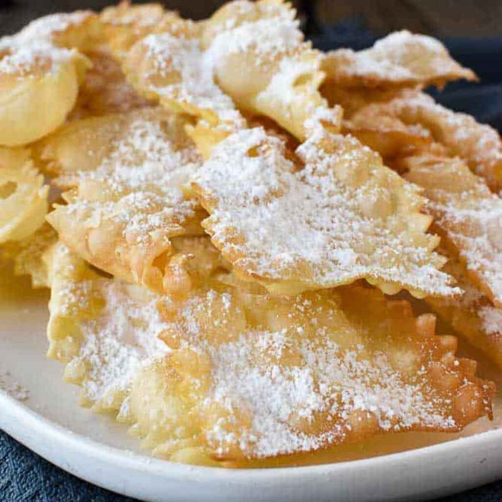 Crostoli dusted with powdered sugar viewed from the front.