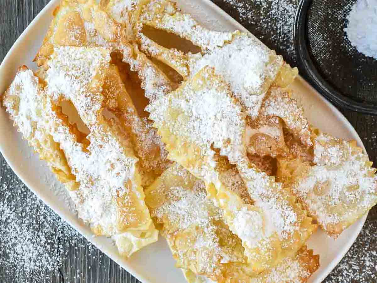 Fried Italian pastries dusted with powdered sugar viewed from above.