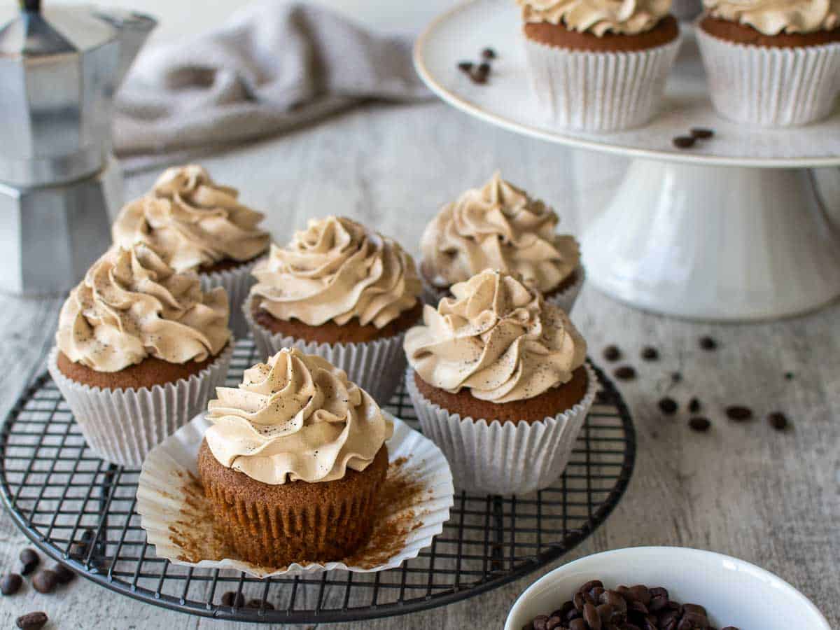 Espresso cupcakes topped with coffee buttercream on a blackwire rack.