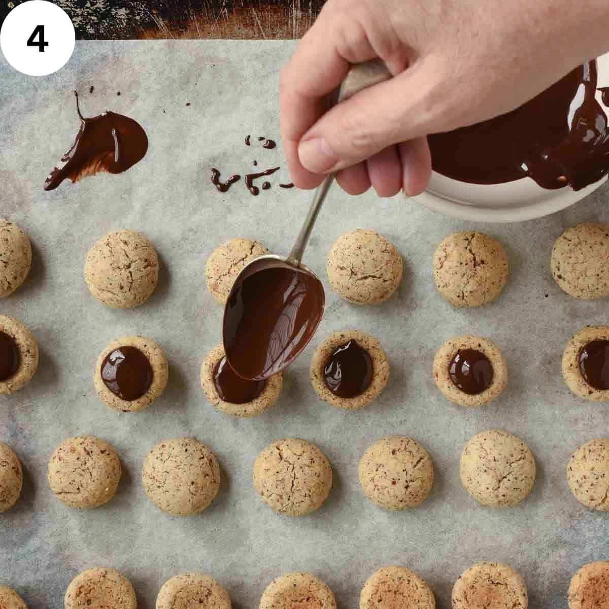 Spooning melted chocolate on upturned cookies.