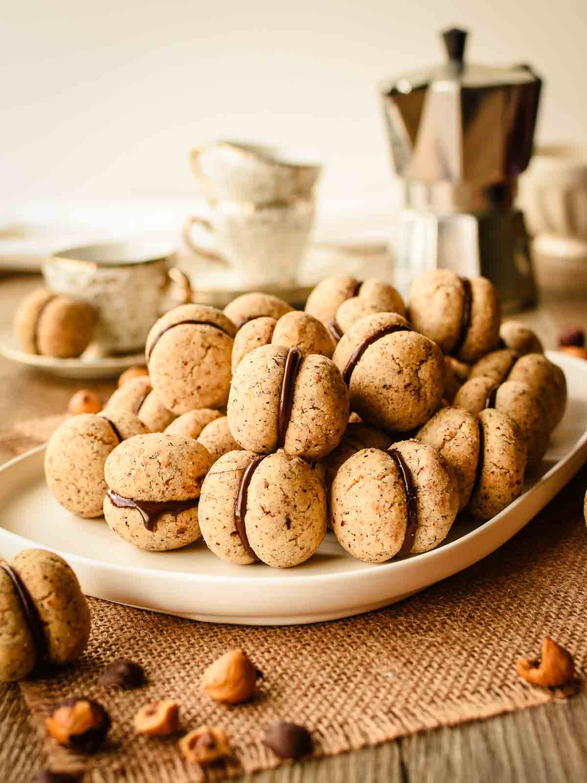 Baci di Dama cookies piled onto a white plate.