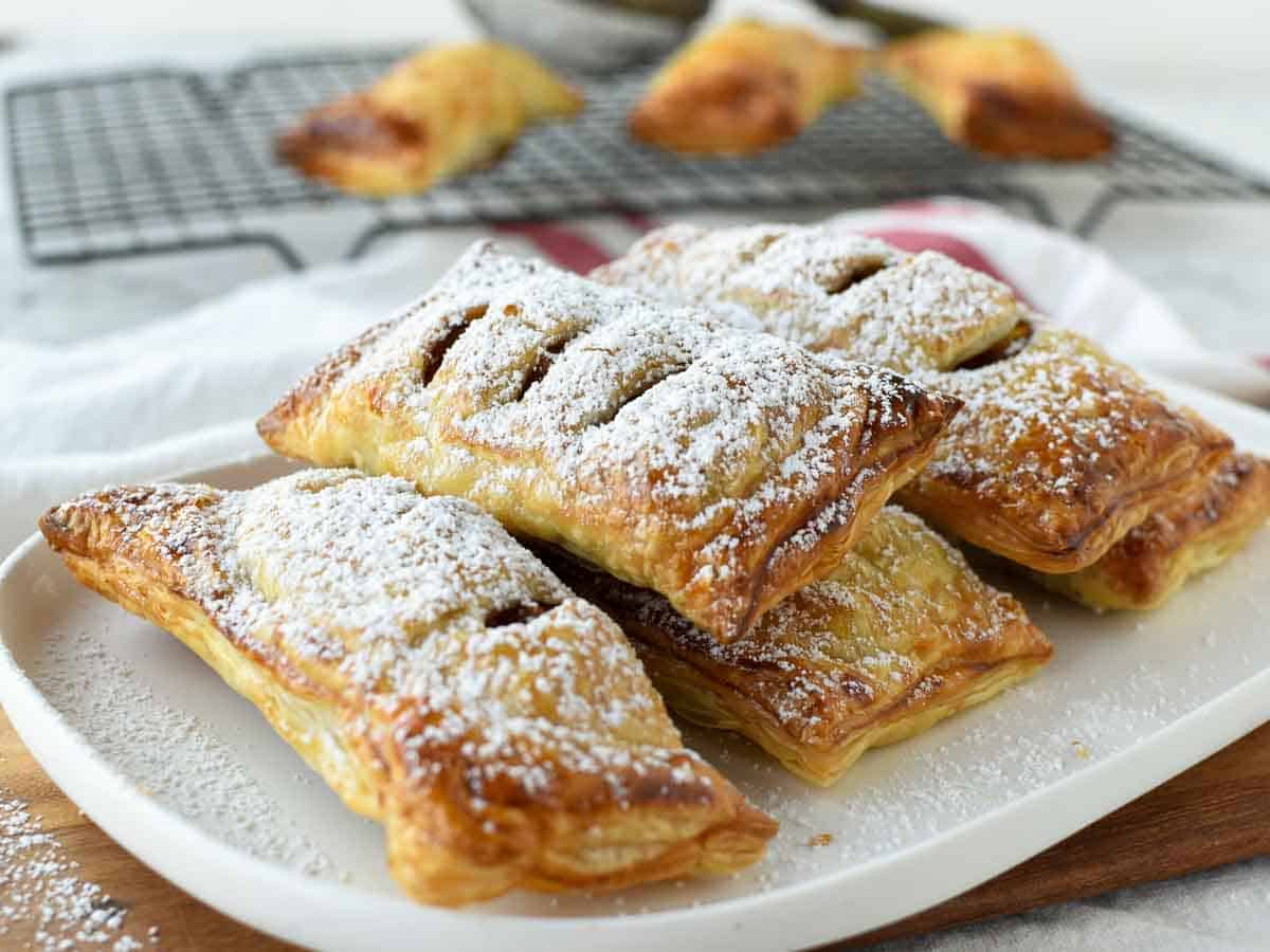 rectangle shaped pastries on a white plate dusting with powdered sugar.