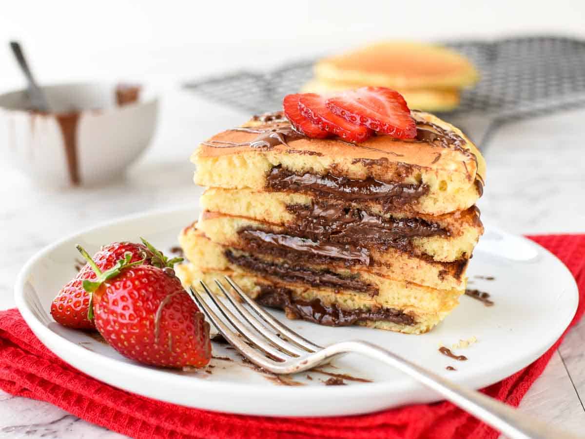 Stack of halves pancakes with melted chocolate inside.