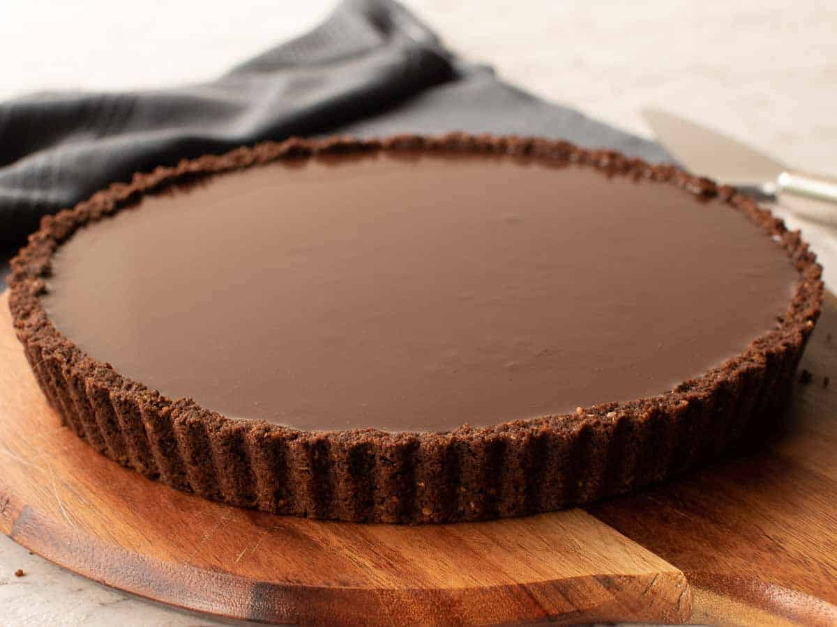 chocolate tart on wooden board.