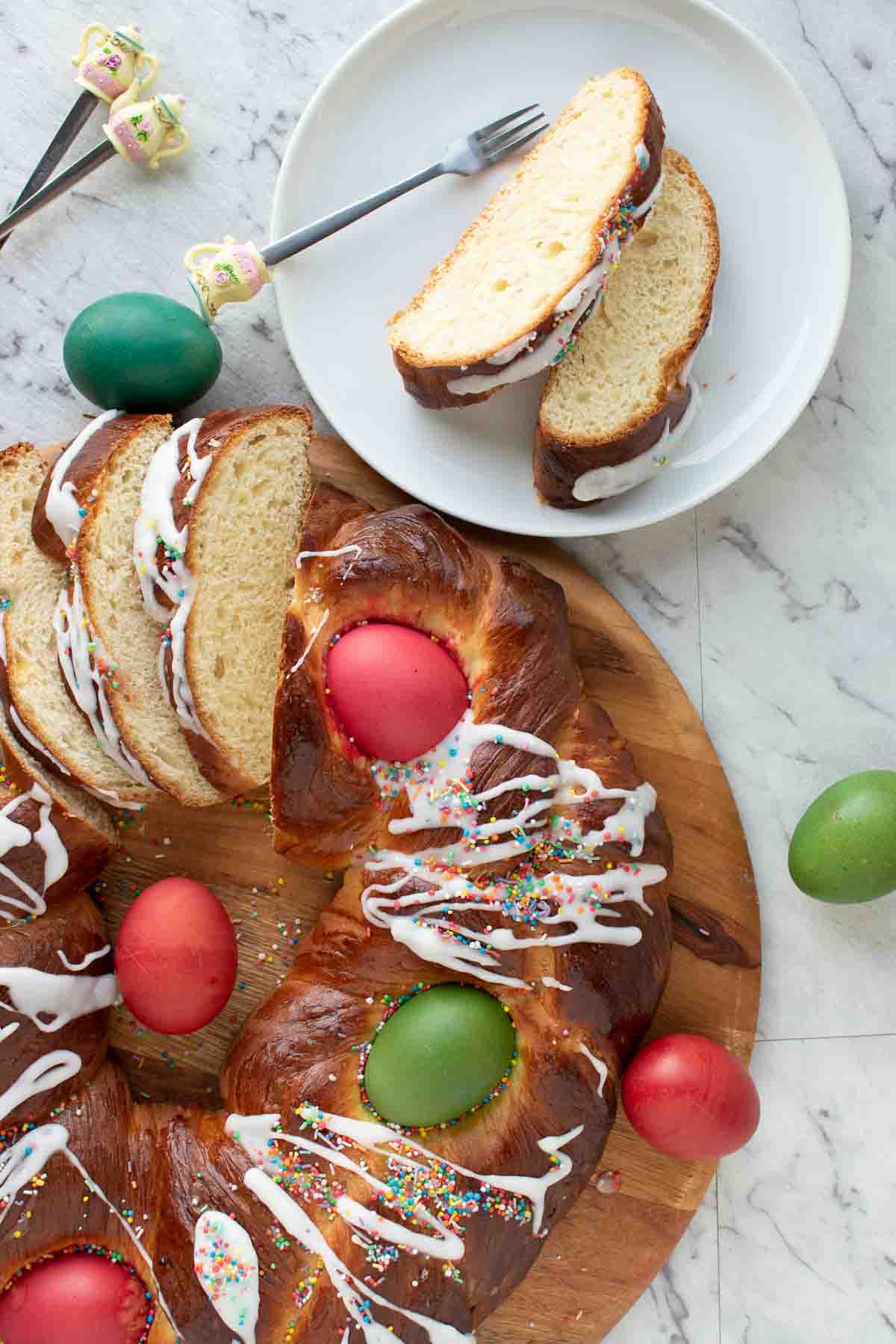 Italian Easter bread served on a wooden board and a slice on a white plate.