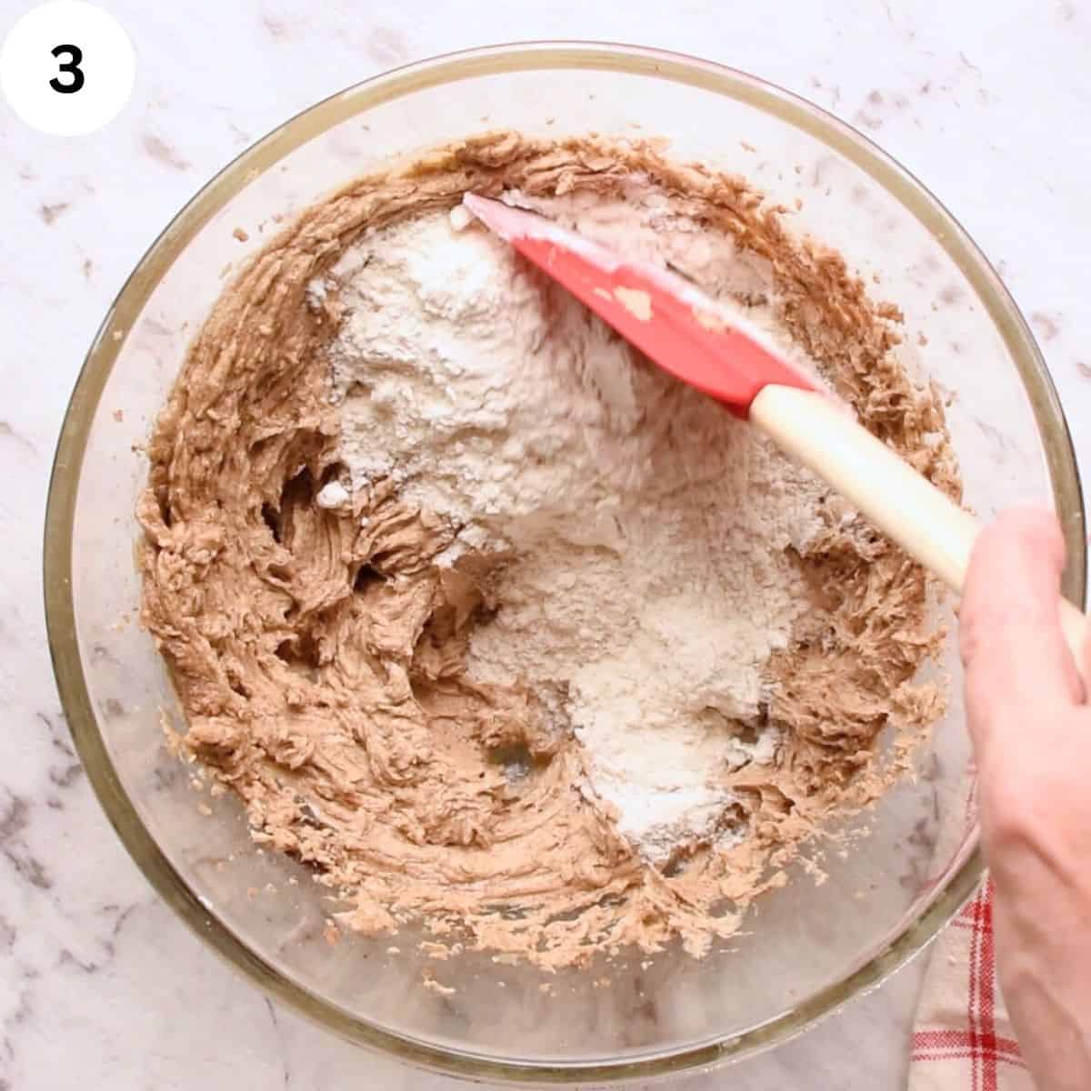 Folding flour into creamy brown mixture.