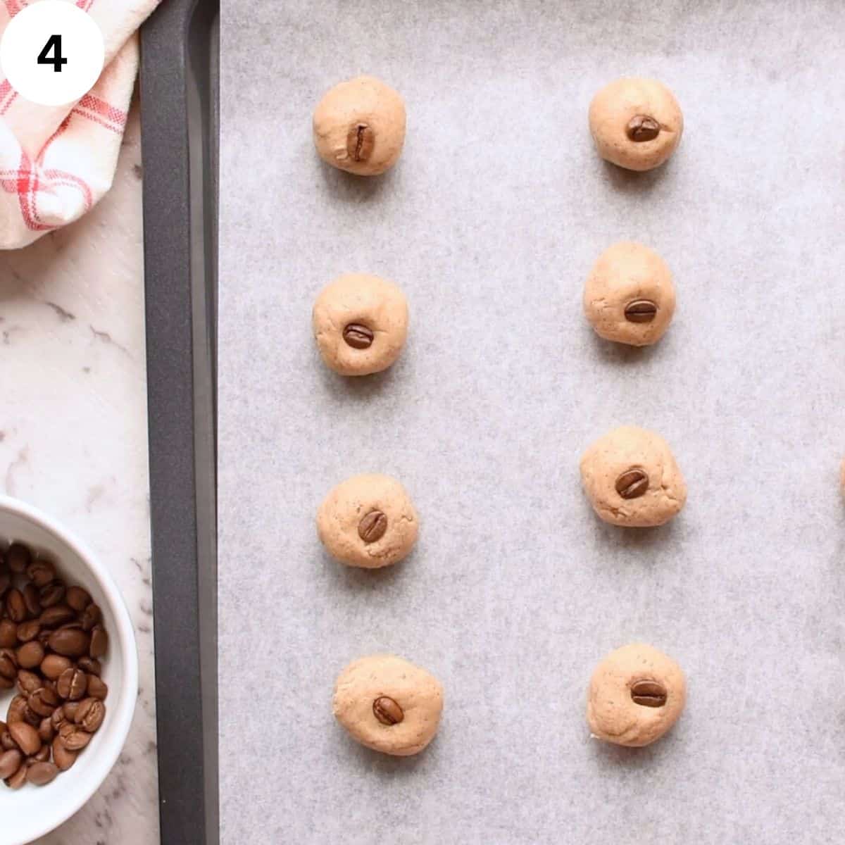 Balls of cookie dough with a coffee bean stuck into each ball.