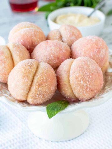 seven Italian Peach Cookies on a white cake plate