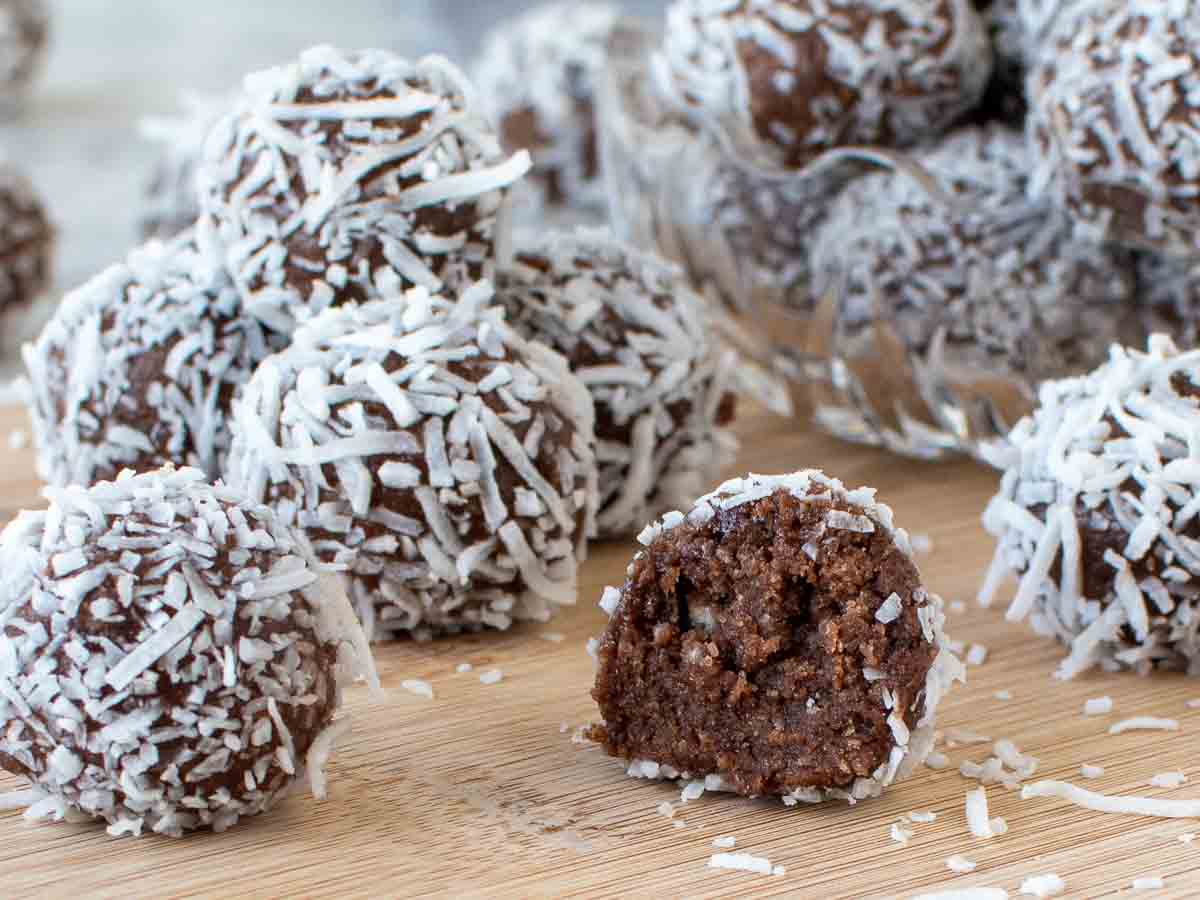 close up of coconut coated chocolate balls including one cut in half.