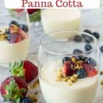 Pinterest Image with text three vanilla panna cotta in glasses with strawberries and blueberries.