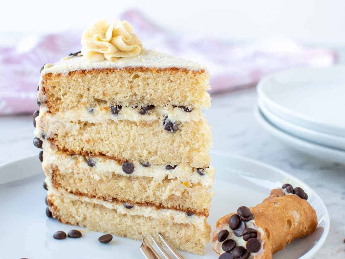 Slice of layered cake filled with cream and chocolate chips.