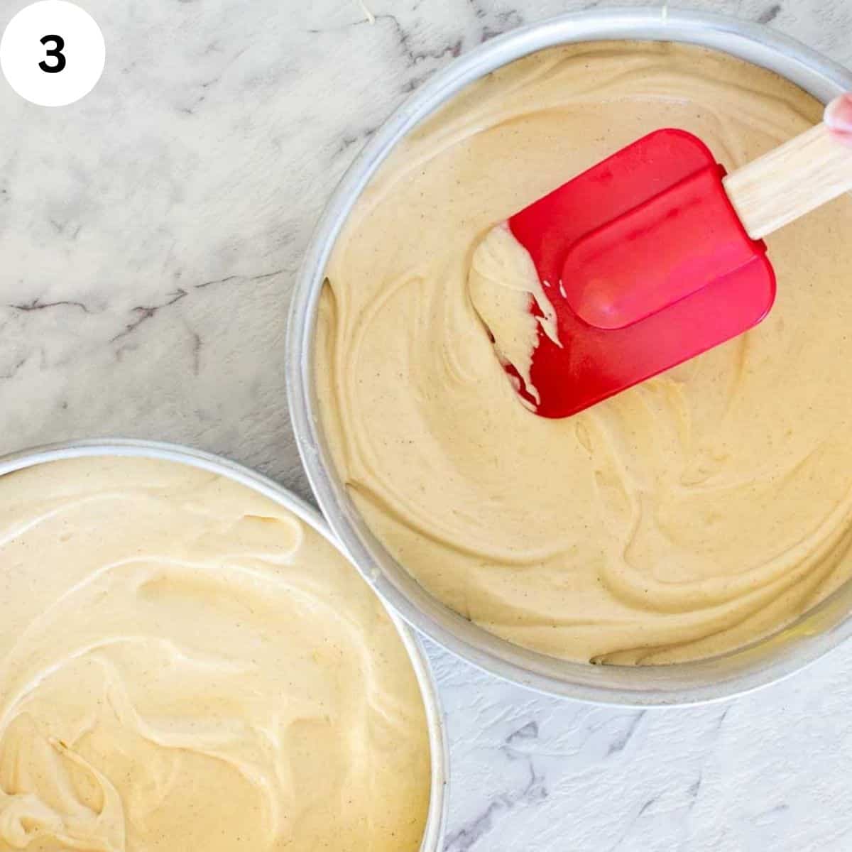 Cake batter being spread into cake pans.