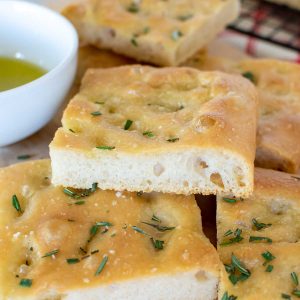 slices of focaccia stacked with white bowl of oil on the side