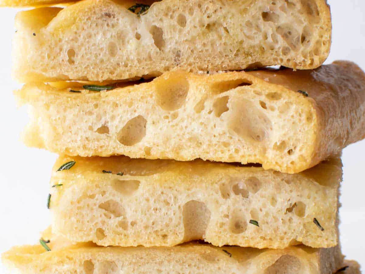 close up of ligurian focaccia slices stack one on top of the other.