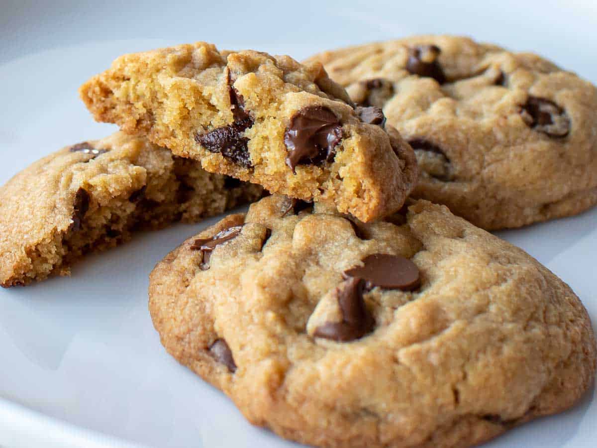 Two cookies with one broken in half on a white plate.