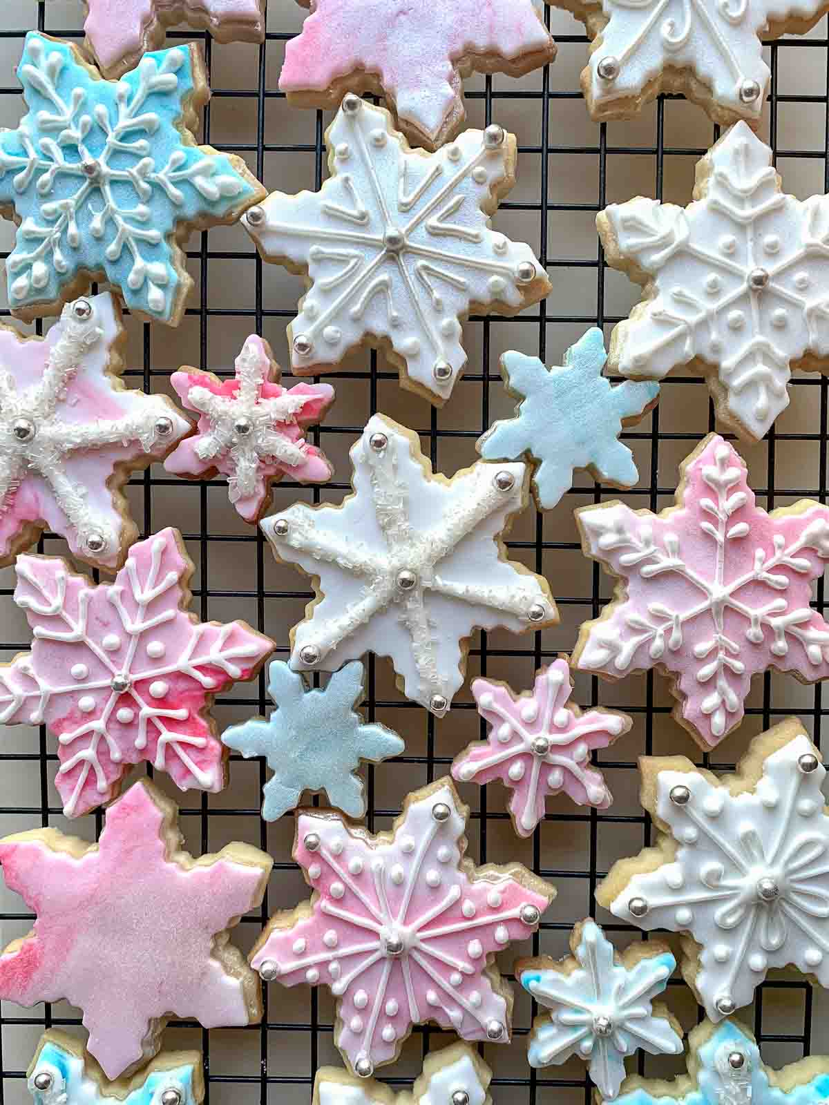 decorated sugar cookies on black wire rack viewed from above.