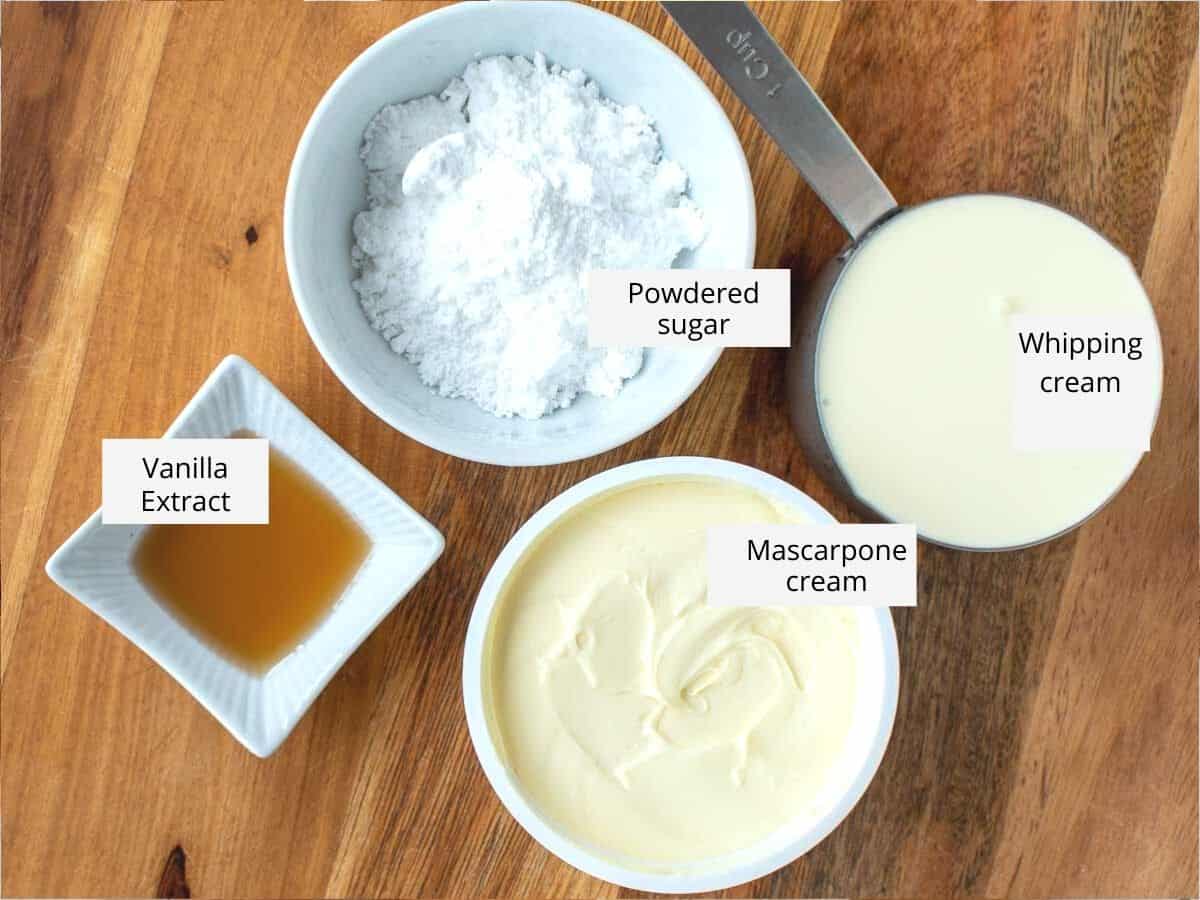 mascarpone cheese, whipping cream, powdered sugar and vanilla extract in bowls viewed from above.