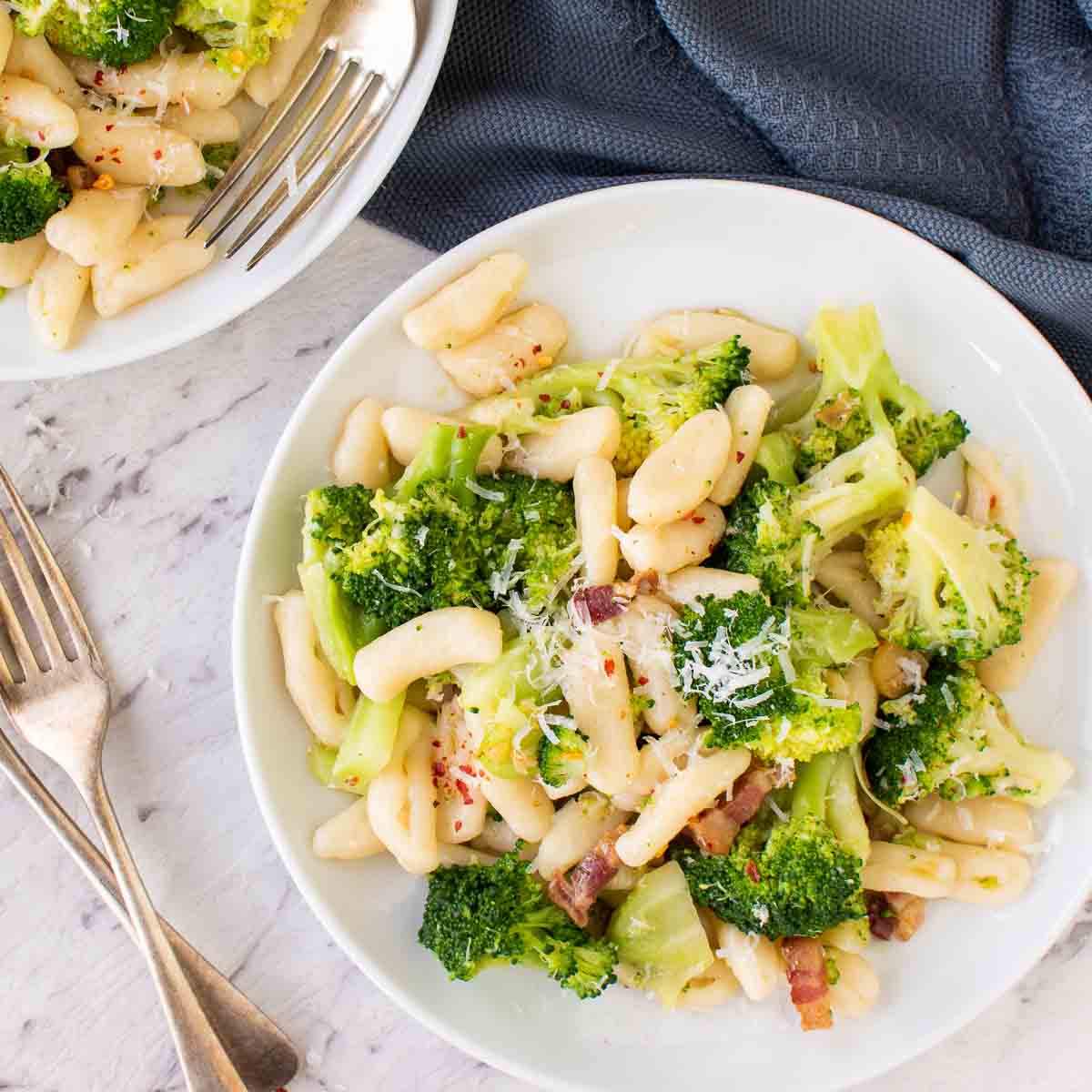 overhead view of broccoli pasta on white plate.