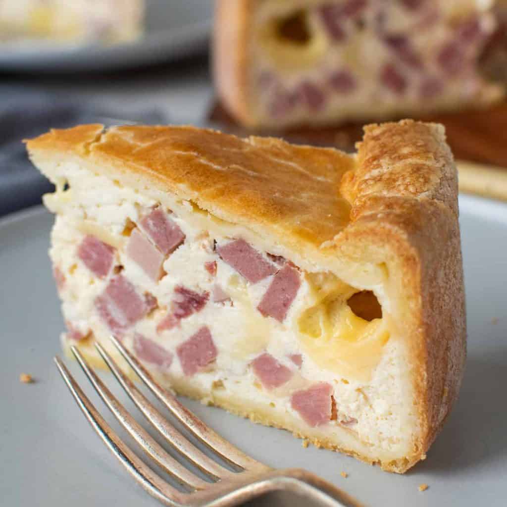 close up of a slice of italian pie with whole pie in the background.