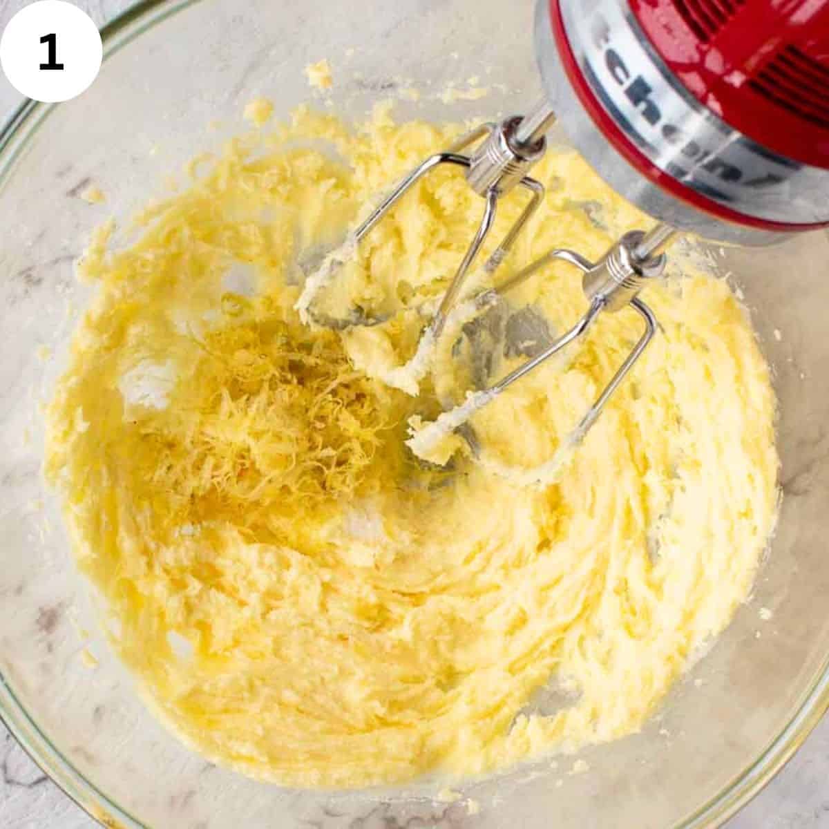 Beating butter and sugar with an electric hand mixer.
