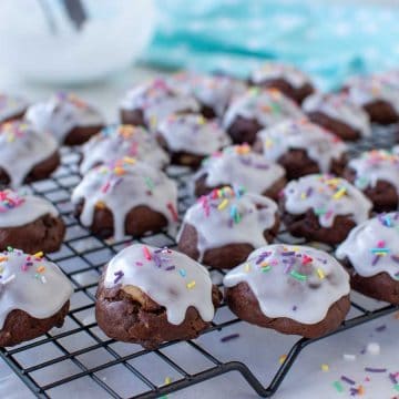 white frosting covered chocolate cookies on wire rack.