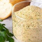 image with text. image reads make your own italian breadcrumbs. image is italian bread crumbs in glass jar with a spoonful of crumbs