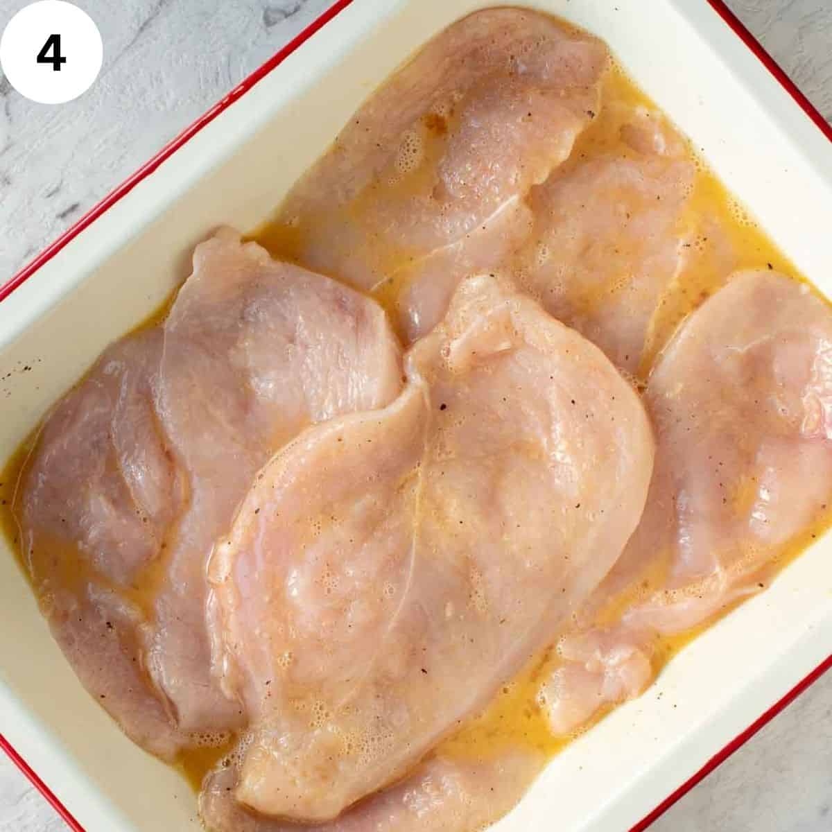 Chicken breasts in eggy marinade.